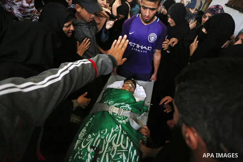 Relatives mourn over the body of Alaa al-Zamili, 15, who who died the day before during clashes with Isareli security forces at the Israel-Gaza border, during his funeral in Rafah in the southern Gaza strip on April 7, 2...