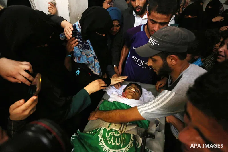 Relatives mourn over the body of Alaa al-Zamili, 15, who who died the day before during clashes with Isareli security forces at the Israel-Gaza border, during his funeral in Rafah in the southern Gaza strip on April 7, 2...