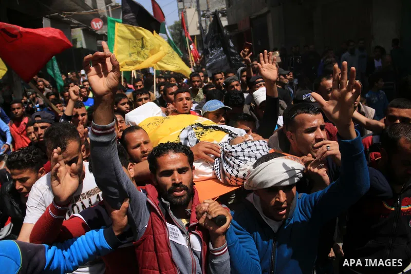 Palestinian mourners carry the body of Ibrahim el-Aar, 18, who who died the day before during clashes with Isareli security forces at the Israel-Gaza border, during his funeral at al-Nusairat refugee camp in the central...