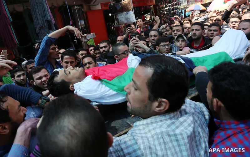 Mourners and journalists carry the body of Palestinian journalist Yasser Murtaja, 30, who died from his injuries after he was shot by Israeli security forces during clashes at the Israel-Gaza border on Friday, during his...