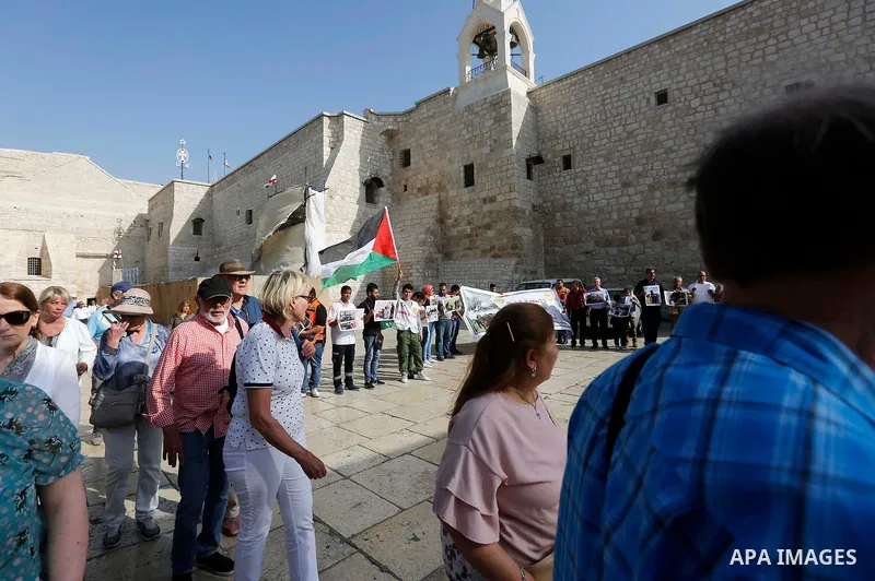 Palestinian medicals hold placards during a protest demanding to stop Israeli attacks on paramedics and journalists outside Church of the Nativity in the West Bank city of Bethlehem, on April 8, 2018. Photo by Wisam Hash...