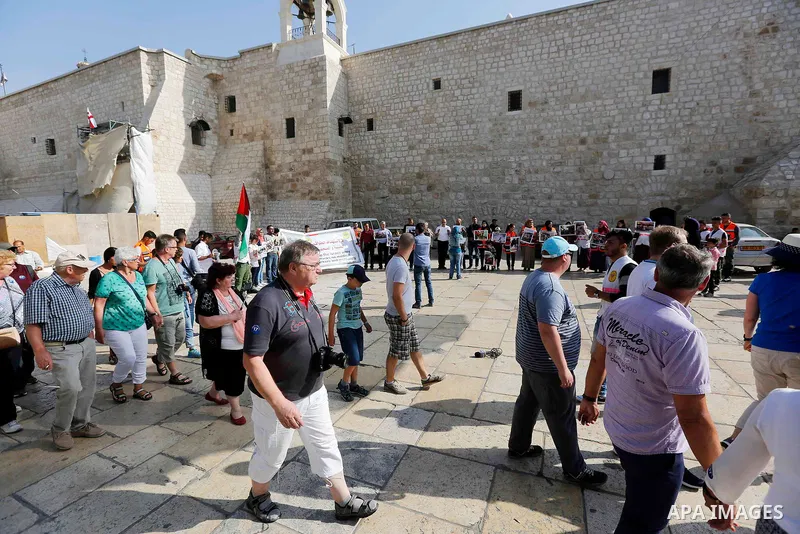 Palestinian medicals hold placards during a protest demanding to stop Israeli attacks on paramedics and journalists outside Church of the Nativity in the West Bank city of Bethlehem, on April 8, 2018. Photo by Wisam Hash...
