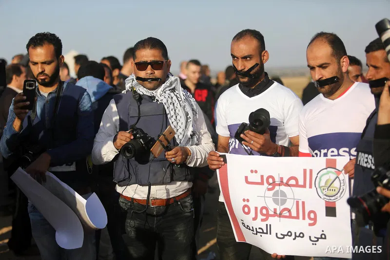 Palestinian journalists take part during a protest demanding to stop Israeli attacks on journalists near the border between Gaza and Israel, in Rafah in the southern Gaza strip on April 8, 2018. Photo by Ashraf Amra
