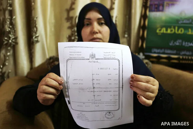 The mother of Palestinian Teenager Hussein Madi, who was killed during clashes with Israeli security forces, holds his birth certificate at her house in Gaza city on April 9, 2018. Photo by Ashraf Amra