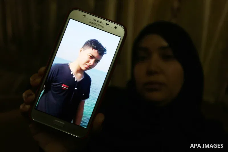 The mother of Palestinian Teenager Hussein Madi, who was killed during clashes with Israeli security forces, holds a mobile phone and showing the picture of her son at her house in Gaza city on April 9, 2018. Photo by As...