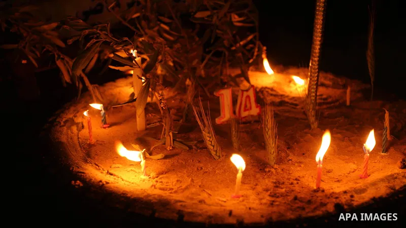 Palestinians light candles during a symbolic birthday party for Palestinian Teenager Hussein Madi, who was killed during clashes with Israeli security forces at the Israel-Gaza border, on his 14th birthday in the east of...