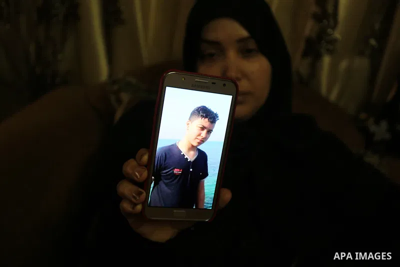 The mother of Palestinian Teenager Hussein Madi, who was killed during clashes with Israeli security forces, holds a mobile phone and showing the picture of her son at her house in Gaza city on April 9, 2018. Photo by As...
