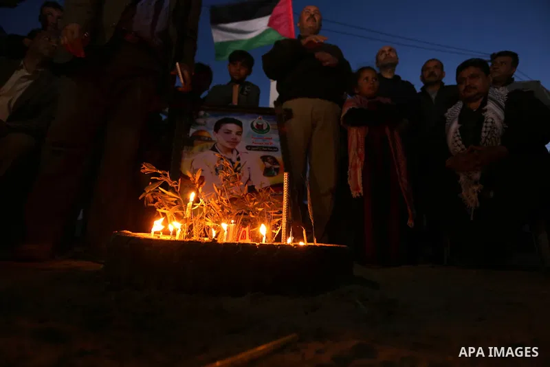 Palestinians light candles during a symbolic birthday party for Palestinian Teenager Hussein Madi, who was killed during clashes with Israeli security forces at the Israel-Gaza border, on his 14th birthday in the east of...