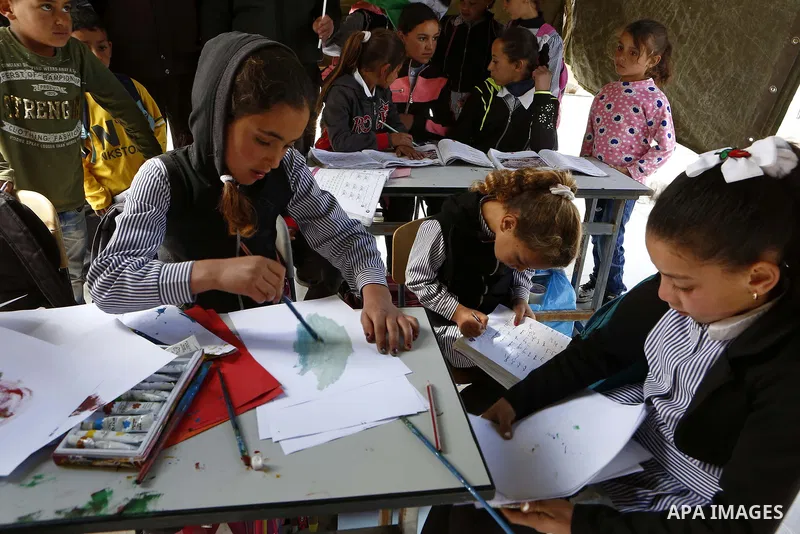 Palestinian schoolchildren attend a class in a tent at the site of their school after it was demolished by Israeli security forces who claim it was built on illegal land, in the West Bank city of Hebron on April 10, 2018...