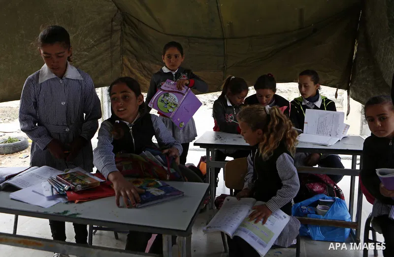 Palestinian schoolchildren attend a class in a tent at the site of their school after it was demolished by Israeli security forces who claim it was built on illegal land, in the West Bank city of Hebron on April 10, 2018...