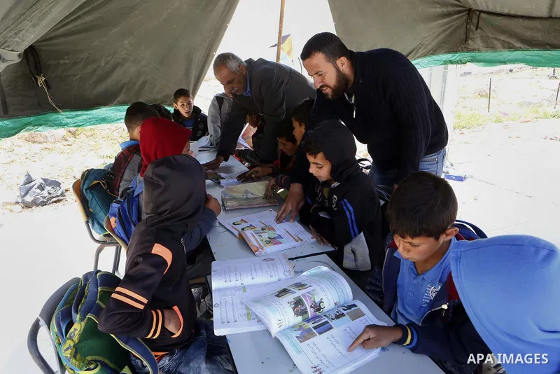 Palestinian schoolchildren attend a class in a tent at the site of their school after it was demolished by Israeli security forces who claim it was built on illegal land, in the West Bank city of Hebron on April 10, 2018...