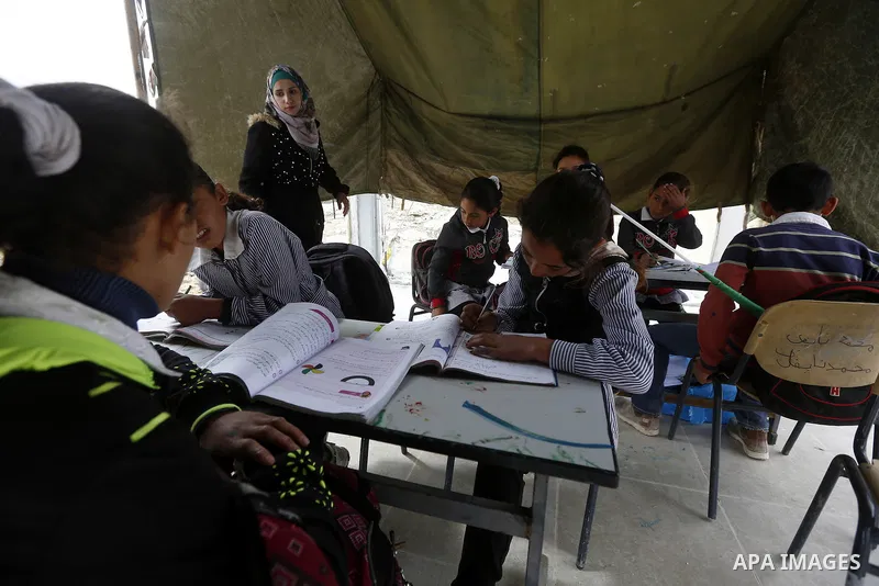 Palestinian schoolchildren attend a class in a tent at the site of their school after it was demolished by Israeli security forces who claim it was built on illegal land, in the West Bank city of Hebron on April 10, 2018...