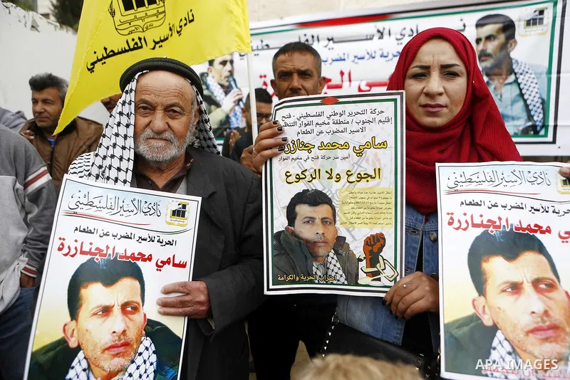 Palestinians hold posters depicting Sami al-Janazra who is in hunger strike at Israeli jails, during a protest to show solidarity with al-Janazra in the West Bank city of Hebron on April 10, 2018. Photo by Wisam Hashlamo...