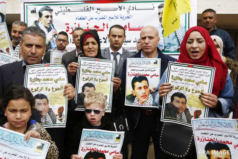 Palestinians hold posters depicting Sami al-Janazra who is in hunger strike at Israeli jails, during a protest to show solidarity with al-Janazra in the West Bank city of Hebron on April 10, 2018. Photo by Wisam Hashlamo...