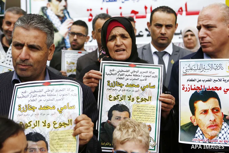 Palestinians hold posters depicting Sami al-Janazra who is in hunger strike at Israeli jails, during a protest to show solidarity with al-Janazra in the West Bank city of Hebron on April 10, 2018. Photo by Wisam Hashlamo...