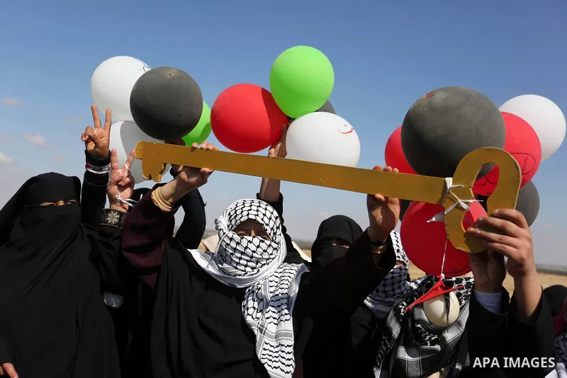 Palestinian women hold balloons during a protest demanding the right to return to their homeland, at the Israel-Gaza border, in Rafah in the southern Gaza Strip on April 10, 2018. Photo by Ashraf Amra
