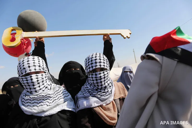 Palestinian women hold balloons during a protest demanding the right to return to their homeland, at the Israel-Gaza border, in Rafah in the southern Gaza Strip on April 10, 2018. Photo by Ashraf Amra