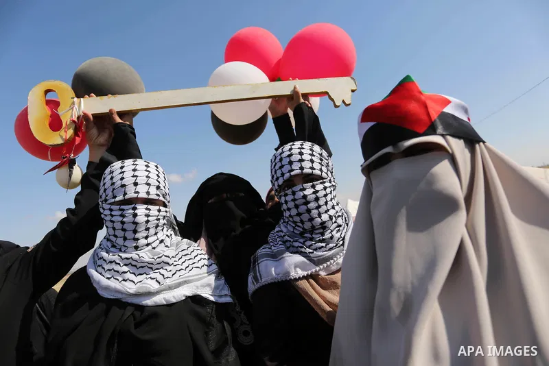 Palestinian women hold balloons during a protest demanding the right to return to their homeland, at the Israel-Gaza border, in Rafah in the southern Gaza Strip on April 10, 2018. Photo by Ashraf Amra
