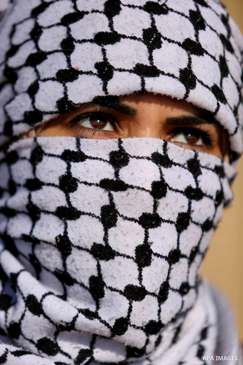 A Palestinian woman looks on during a protest demanding the right to return to their homeland, at the Israel-Gaza border, in Rafah in the southern Gaza Strip on April 10, 2018. Photo by Ashraf Amra