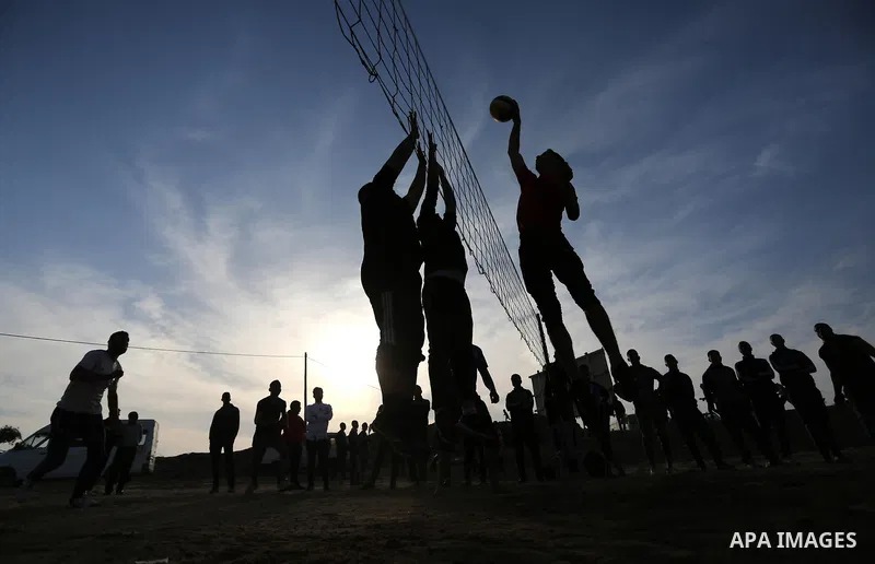 Palestinians play volleyball near tents during a tent city protest demanding the right to return to their homeland, at the Israel-Gaza border in the east of Gaza city on April 11, 2018. Photo by Ashraf Amra