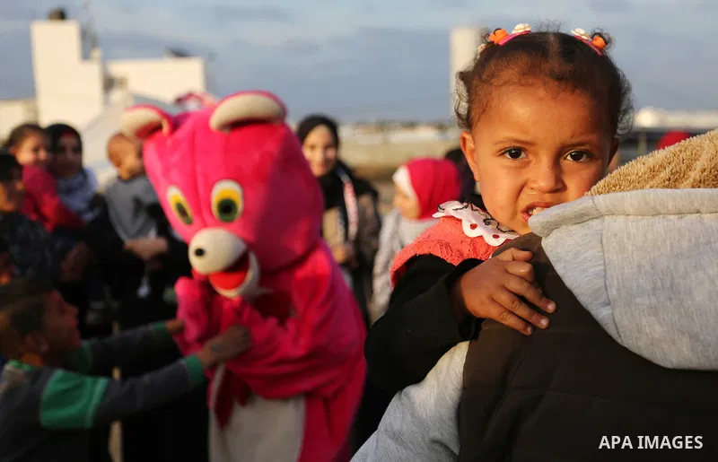 A Palestinian man wearing costume is seen near tents during a tent city protest demanding the right to return to their homeland, at the Israel-Gaza border in the east of Gaza city on April 11, 2018. Photo by Ashraf Amra