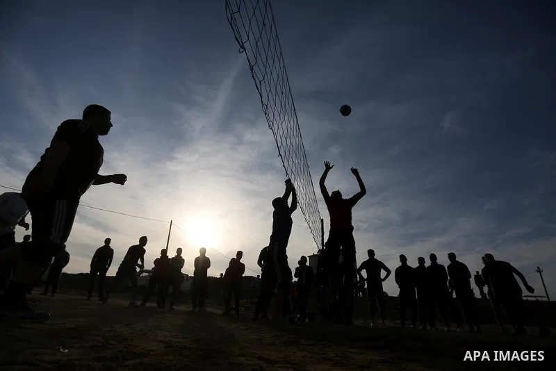 Palestinians play volleyball near tents during a tent city protest demanding the right to return to their homeland, at the Israel-Gaza border in the east of Gaza city on April 11, 2018. Photo by Ashraf Amra