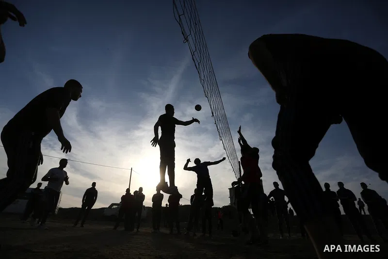 Palestinians play volleyball near tents during a tent city protest demanding the right to return to their homeland, at the Israel-Gaza border in the east of Gaza city on April 11, 2018. Photo by Ashraf Amra