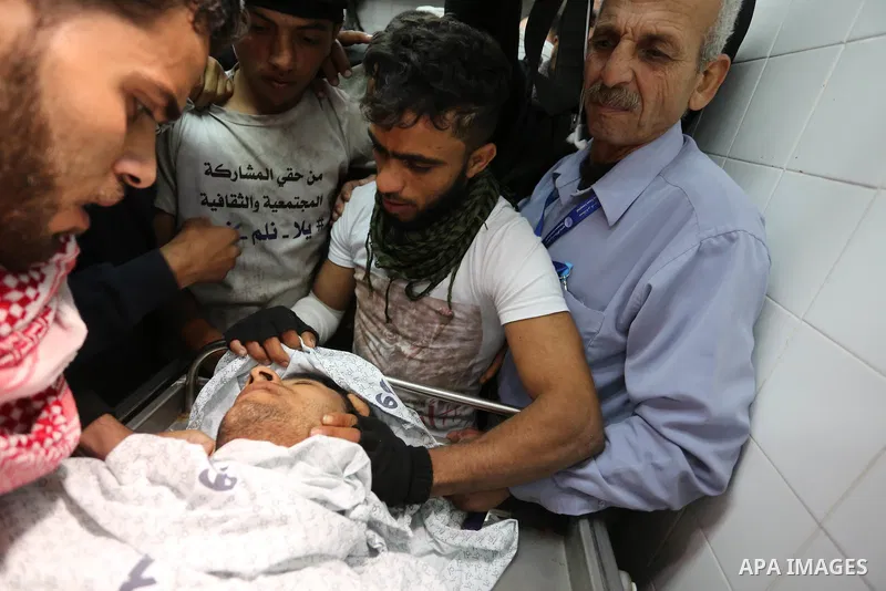 Relatives mourn over the body of Abdullah Al-Shehri, 28, who was killed along Israel border with Gaza, at a hospital in the southern Gaza Strip Apri 12, 2018. Photo by Ashraf Amra