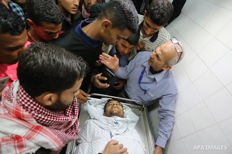 Relatives mourn over the body of Abdullah Al-Shehri, 28, who was killed along Israel border with Gaza, at a hospital in the southern Gaza Strip Apri 12, 2018. Photo by Ashraf Amra