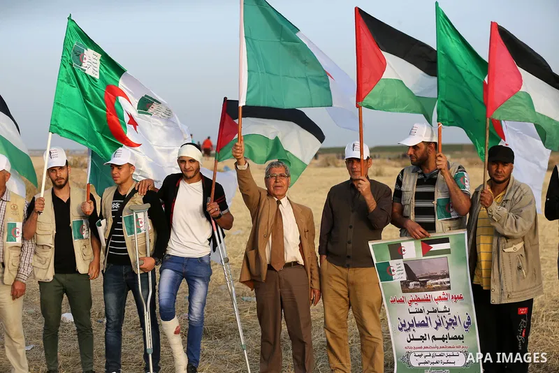 Palestinians wave the national flag and flags of Algeria next to the Gaza border with Israel, east of Gaza, Gaza Strip, 12 April 2018. The protest is named "The Great March of Return" to mark the annual Land Day, which c...