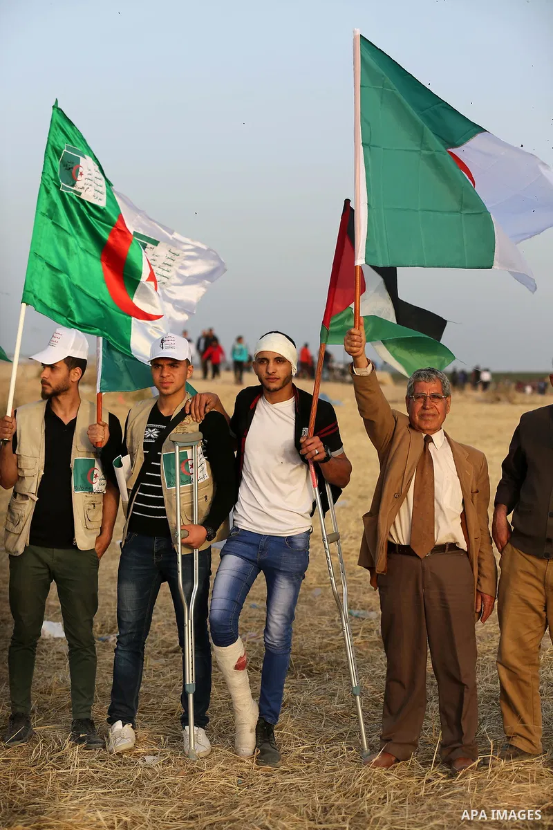 Palestinians wave the national flag and flags of Algeria next to the Gaza border with Israel, east of Gaza, Gaza Strip, 12 April 2018. The protest is named "The Great March of Return" to mark the annual Land Day, which c...