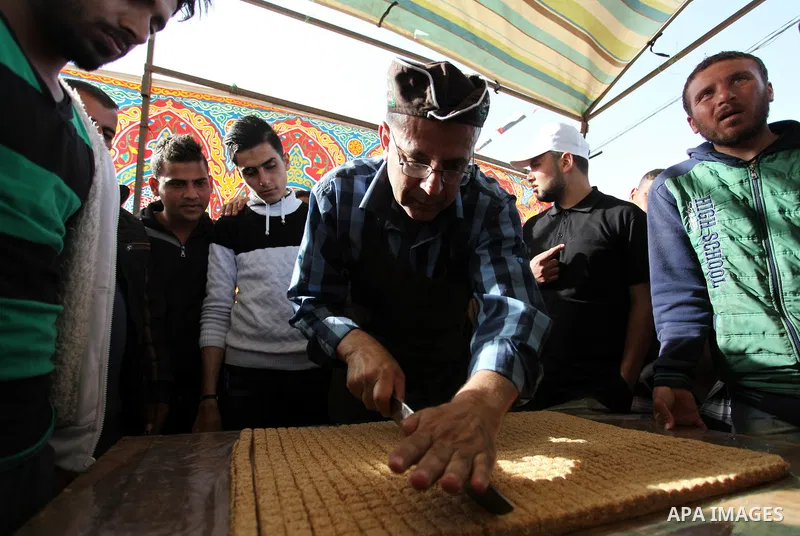 A Palestinian man prepares a traditional sweet known as "Sesame" during a tent city protest demanding the right to return to their homeland, at the Israel-Gaza border in the east of Gaza city on April 12, 2018. Photo by...