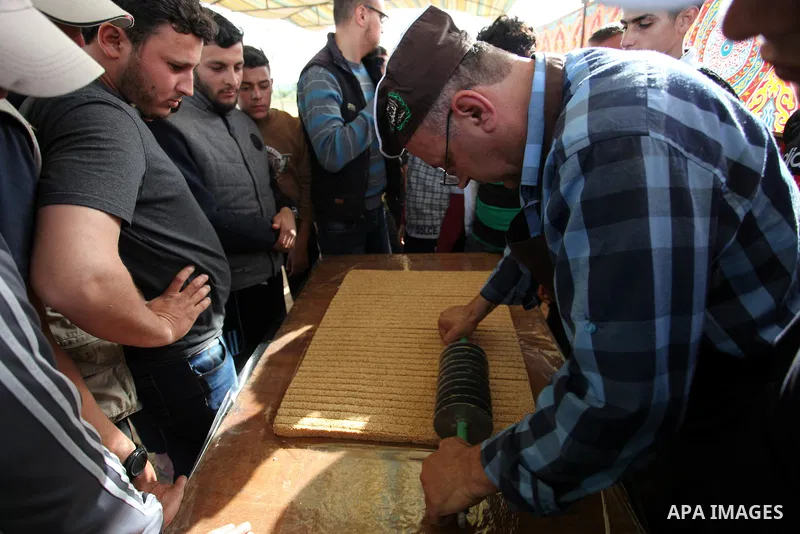 A Palestinian man prepares a traditional sweet known as "Sesame" during a tent city protest demanding the right to return to their homeland, at the Israel-Gaza border in the east of Gaza city on April 12, 2018. Photo by...