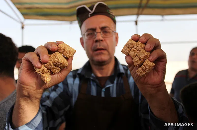A Palestinian man prepares a traditional sweet known as "Sesame" during a tent city protest demanding the right to return to their homeland, at the Israel-Gaza border in the east of Gaza city on April 12, 2018. Photo by...