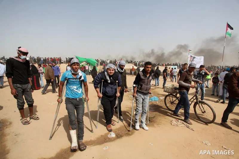 Palestinians gather during clashes with Israeli security forces in a tent city protest where Palestinians demand the right to return to their homeland, at the Israel-Gaza border, in Khan Younis in the southern Gaza Strip...