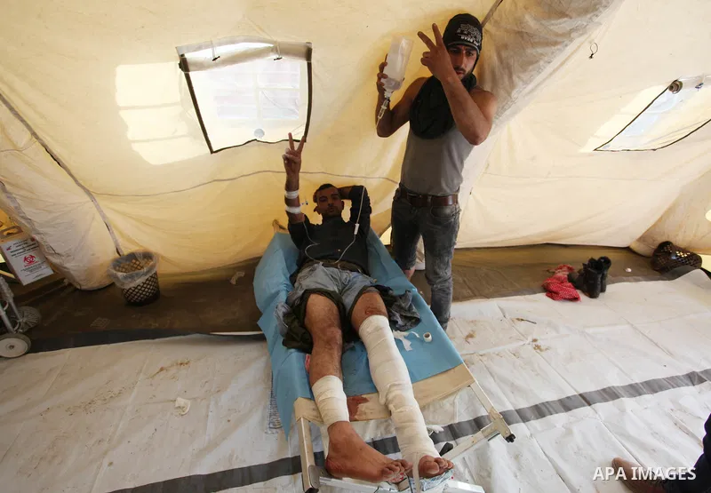 An injured Palestinian protester who was wounded during clashes with Israeli security forces recives treatment at a medical tent in a tent city protest where Palestinians demand the right to return to their homeland, at...
