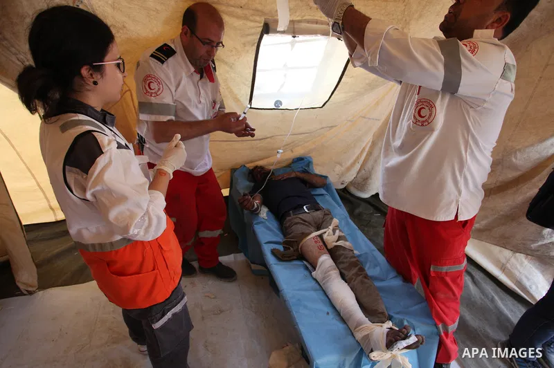 Members of Palestinian medical staff provide treatment for An injured Palestinian protester who was wounded during clashes with Israeli security forces at a medical tent in a tent city protest where Palestinians demand t...