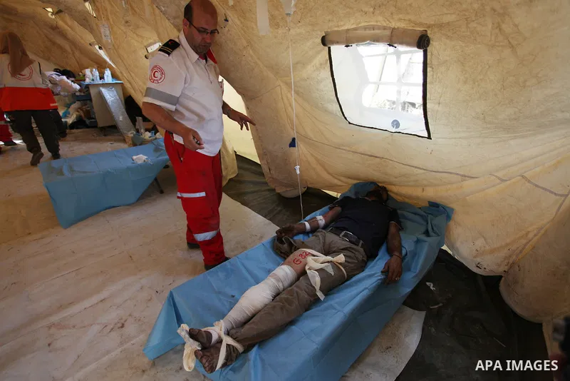 Members of Palestinian medical staff provide treatment for An injured Palestinian protester who was wounded during clashes with Israeli security forces at a medical tent in a tent city protest where Palestinians demand t...