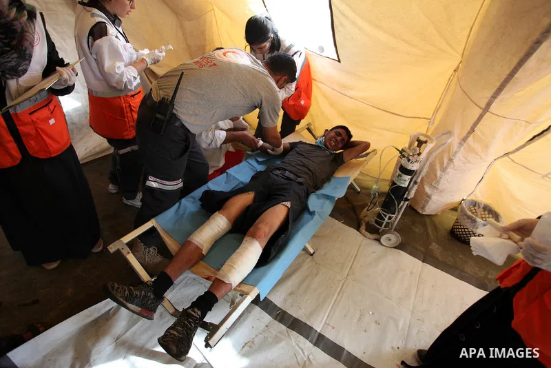 Members of Palestinian medical staff provide treatment for An injured Palestinian protester who was wounded during clashes with Israeli security forces at a medical tent in a tent city protest where Palestinians demand t...