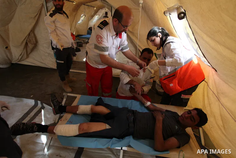 Members of Palestinian medical staff provide treatment for An injured Palestinian protester who was wounded during clashes with Israeli security forces at a medical tent in a tent city protest where Palestinians demand t...
