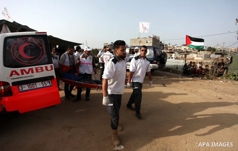 Members of Palestinian medical staff carry An injured Palestinian protester who was wounded during clashes with Israeli security forces in a tent city protest where Palestinians demand the right to return to their homela...