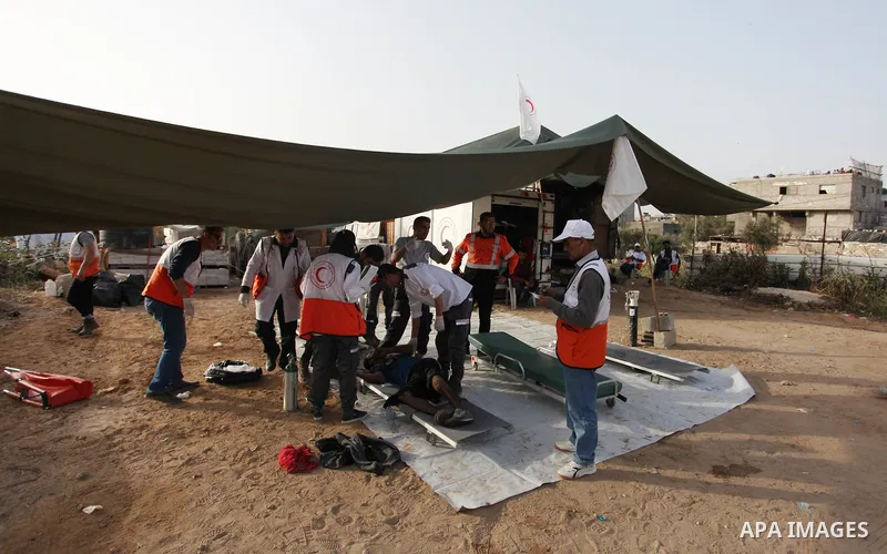 Members of Palestinian medical staff carry An injured Palestinian protester who was wounded during clashes with Israeli security forces in a tent city protest where Palestinians demand the right to return to their homela...