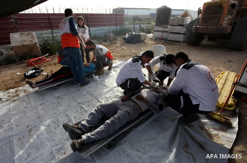 Members of Palestinian medical staff provide treatment for An injured Palestinian protester who was wounded during clashes with Israeli security forces in a tent city protest where Palestinians demand the right to return...