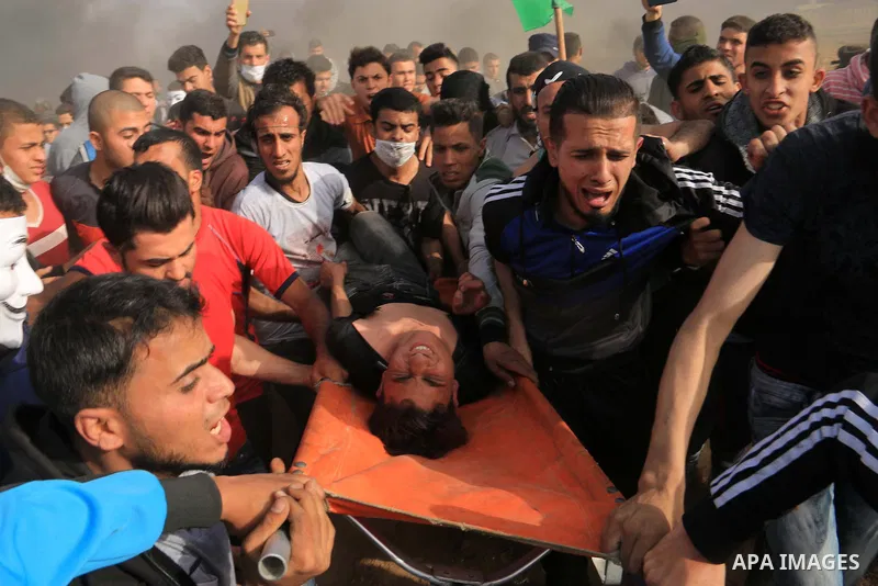A wounded Palestinian protester is evacuated during clashes with Israeli security forces in a tent city protest where Palestinians demand the right to return to their homeland, at the Israel-Gaza border, in the cetner of...