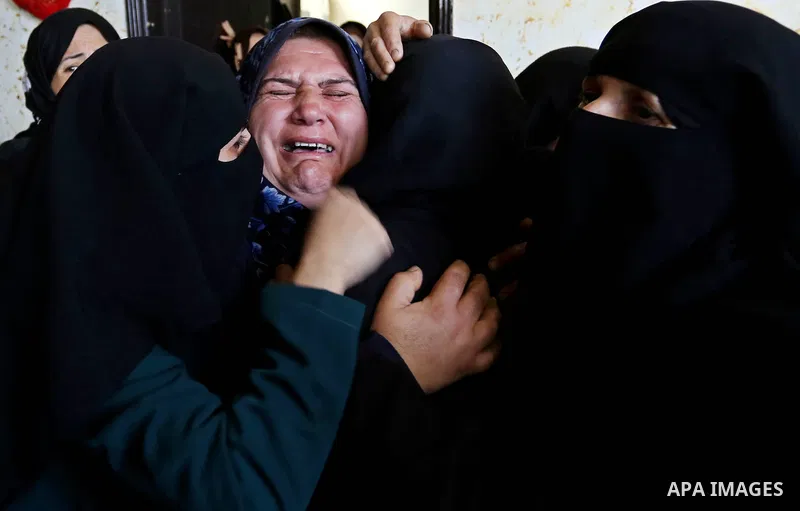 Female relatives of Islam Herzallah, 28, who was killed during clashes with Israeli security forces at the Israel-Gaza border, mourn during his funeral in Gaza City on April 14, 2018. Photo by Ashraf Amra