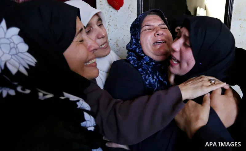Female relatives of Islam Herzallah, 28, who was killed during clashes with Israeli security forces at the Israel-Gaza border, mourn during his funeral in Gaza City on April 14, 2018. Photo by Ashraf Amra