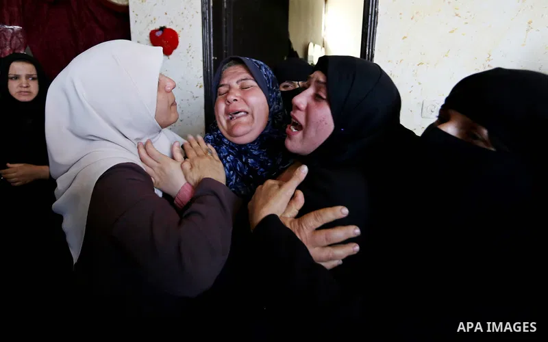 Female relatives of Islam Herzallah, 28, who was killed during clashes with Israeli security forces at the Israel-Gaza border, mourn during his funeral in Gaza City on April 14, 2018. Photo by Ashraf Amra