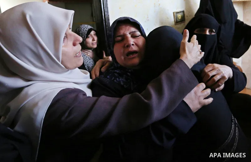 Female relatives of Islam Herzallah, 28, who was killed during clashes with Israeli security forces at the Israel-Gaza border, mourn during his funeral in Gaza City on April 14, 2018. Photo by Ashraf Amra