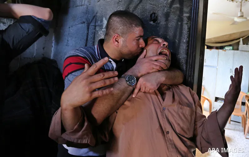 Palestinian men mourn during the funeral of of Islam Herzallah, 28, who was killed during clashes with Israeli security forces at the Israel-Gaza border, in Gaza City on April 14, 2018. Photo by Ashraf Amra