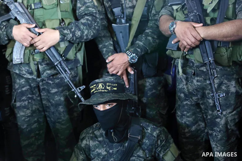 Palestinian militants from the Al-Quds Brigades, the armed wing of the Islamic Jihad movement attend the funeral of their comrades who were killed in an explosion in the previous day, in Rafah in the southern Gaza Strip...